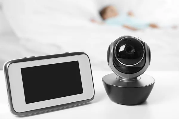 Babyfon und Kamera auf dem Tisch neben dem Bett mit Kind im Zimmer. Video-Kindermädchen — Stockfoto