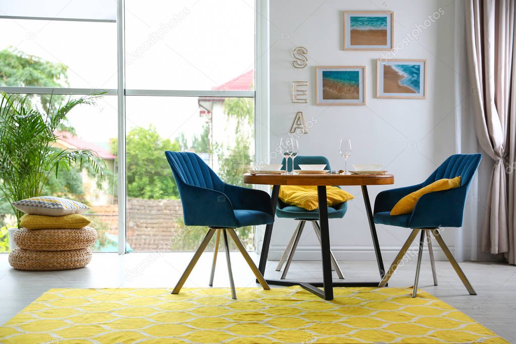 Modern dining room interior with served table and chairs