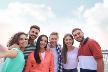 Güneşli bir günde dışarıda selfie çeken mutlu gençler