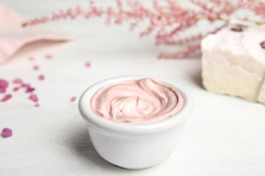 Beyaz ahşap masa üzerinde çiçek ile profesyonel yüz maskesi