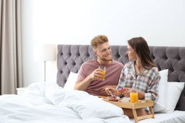 Evde yatakta romantik kahvaltı mutlu genç çift