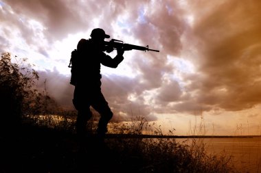 Dışarıda devriye gezen makineli tüfekli bir asker. Askerlik hizmeti