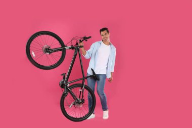 Pembe arka plan üzerinde modern bisiklet ile Yakışıklı genç adam