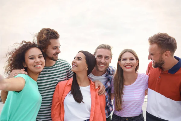 Jóvenes felices tomando selfie al aire libre en un día soleado — Foto de Stock