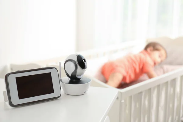 Babyphone und Kamera auf dem Tisch in der Nähe des Kinderbettes mit Kind im Zimmer. Video-Kindermädchen — Stockfoto