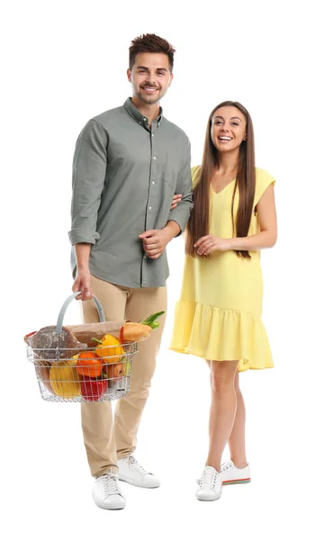 Young couple with shopping basket full of products isolated on white — Stock Photo, Image