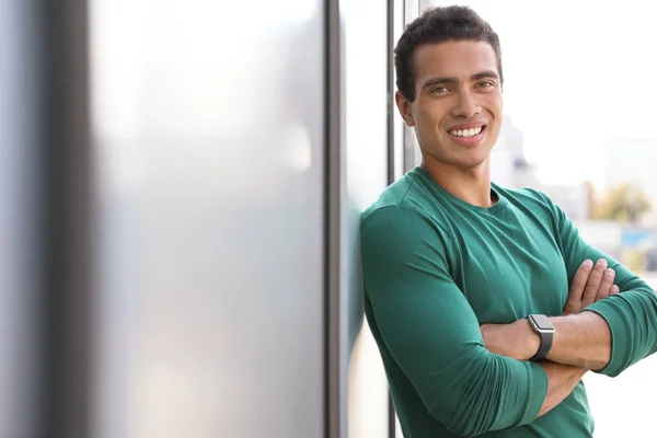 Handsome young African-American man near wall on city street. Space for text