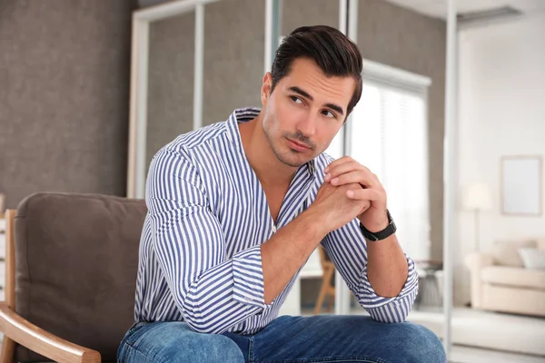 Portrait sur beau jeune homme assis dans la chaise à l'intérieur — Photo