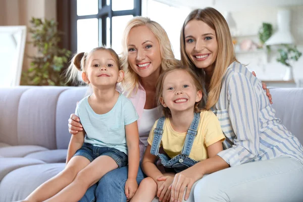 Små flickor med sin mor och farmor i vardagsrummet — Stockfoto