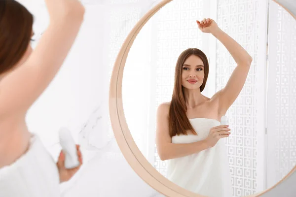Belle jeune femme appliquant déodorant après la douche dans la salle de bain — Photo