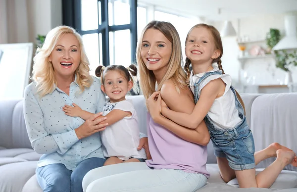 Młoda kobieta z dojrzałą matką i małymi córkami w salonie — Zdjęcie stockowe