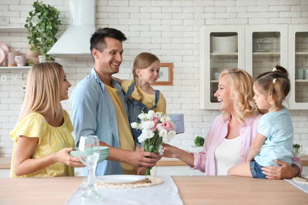 Щаслива сім'я з маленькими дітьми вітаємо бабусю на кухні — стокове фото