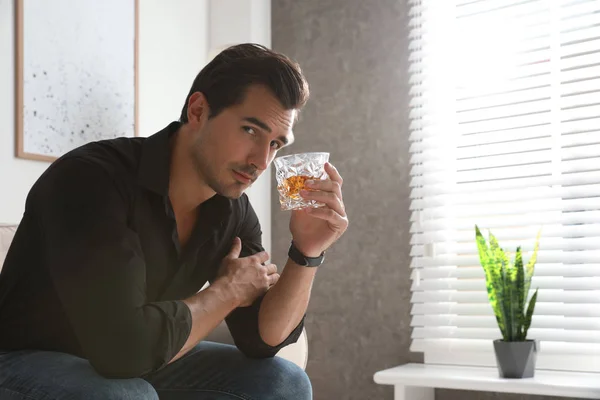 Jeune homme avec un verre de whisky à la maison. Espace pour le texte — Photo