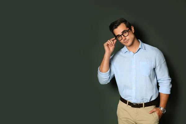 Snygg ung man i snygga kläder med glasögon på mörk bakgrund. Utrymme för text — Stockfoto