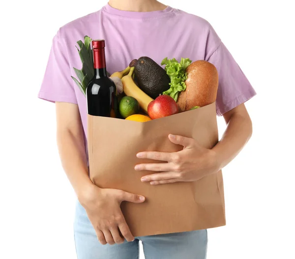 Mujer sosteniendo bolsa de papel de compras con diferentes comestibles sobre fondo blanco —  Fotos de Stock