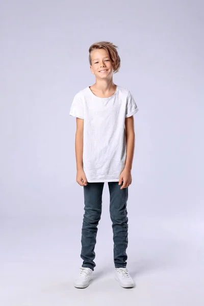 Roztomilý chlapeček v příležitostných šatech na světlým pozadí — Stock fotografie