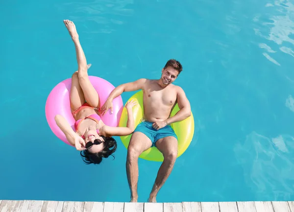 Frau im Bikini mit Freund beim Schwimmen im Resort. glückliches junges Paar — Stockfoto