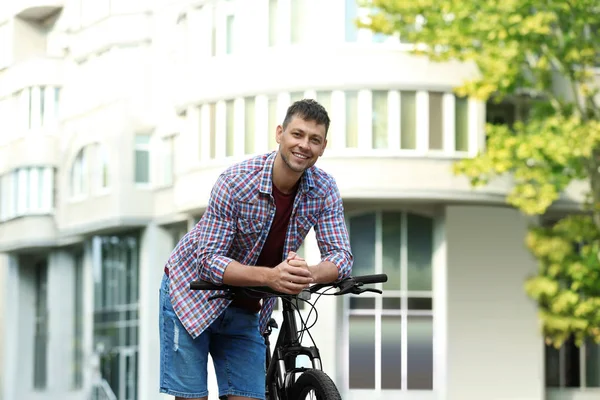 Pohledný muž s moderním bicyklu na městské ulici — Stock fotografie