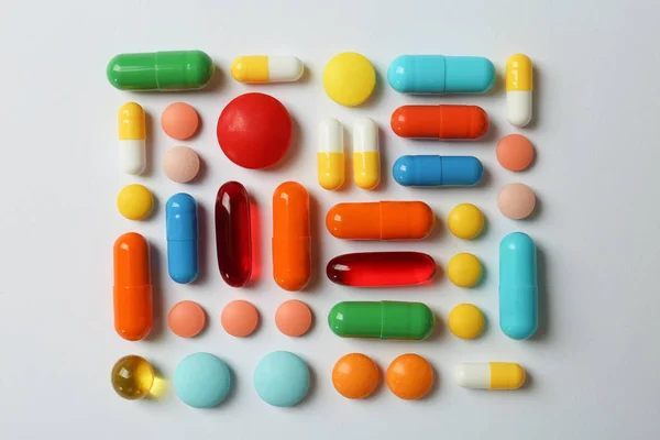 Molte pillole diverse su sfondo bianco, vista dall'alto — Foto Stock