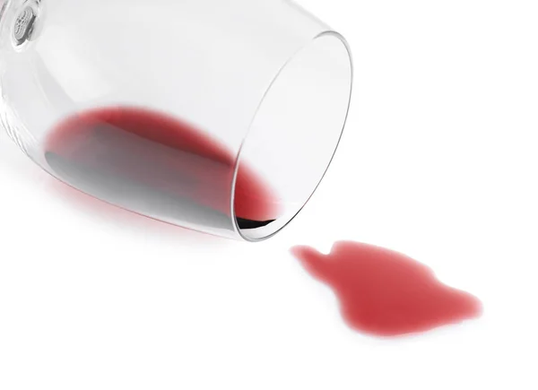 Transparent glass and spilled exquisite red wine on white background — Stock Photo, Image