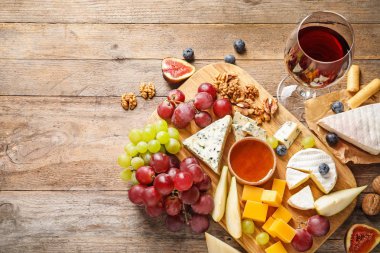 Ahşap arka plan üzerinde lezzetli peynir ve aperatifler Kurulu, düz yatıyordu. Metin için alan
