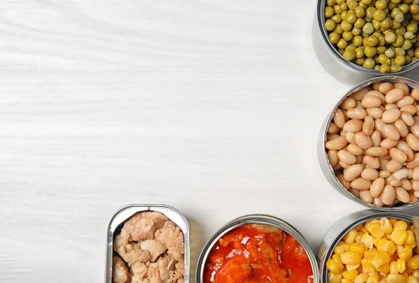 Offene Blechdosen mit verschiedenen Gemüse- und Fischgerichten auf hellem Tisch, flach gelegt. Raum für Text — Stockfoto