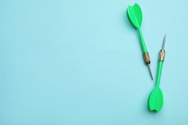 Зеленый дротик стрелки на синем фоне, плоский лежал с пространством для текста
