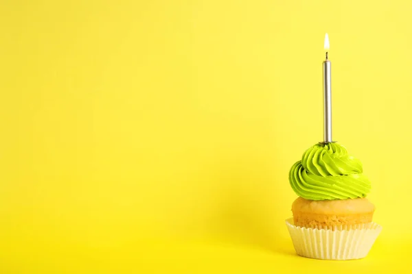 Cupcake d'anniversaire avec bougie sur fond jaune, espace pour le texte — Photo