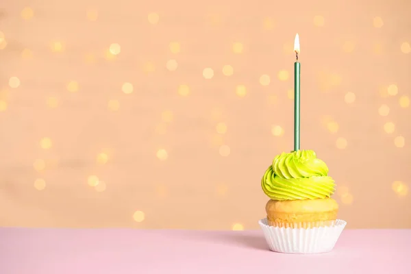 Cupcake d'anniversaire avec bougie sur la table contre les lumières festives — Photo