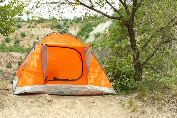Barraca de acampamento laranja perto de árvore no deserto — Fotografia de Stock