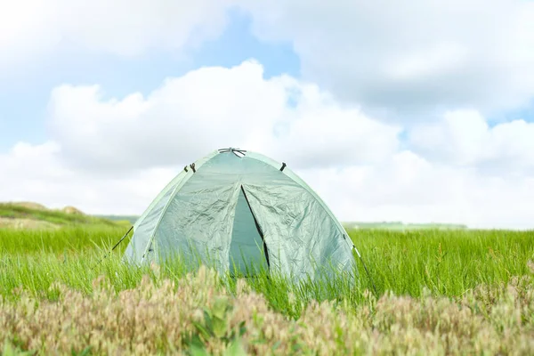 Tenda de acampamento moderna no campo verde no dia ensolarado. Espaço para texto — Fotografia de Stock
