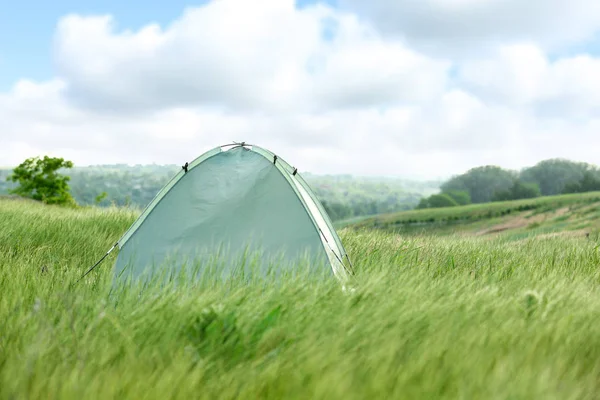 Tienda de campaña moderna en el campo verde en el día soleado. Espacio para texto — Foto de Stock