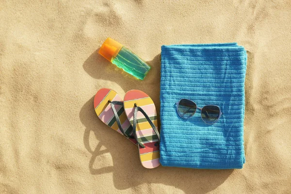 Composición plana de objetos de playa y toalla sobre arena, espacio para texto — Foto de Stock