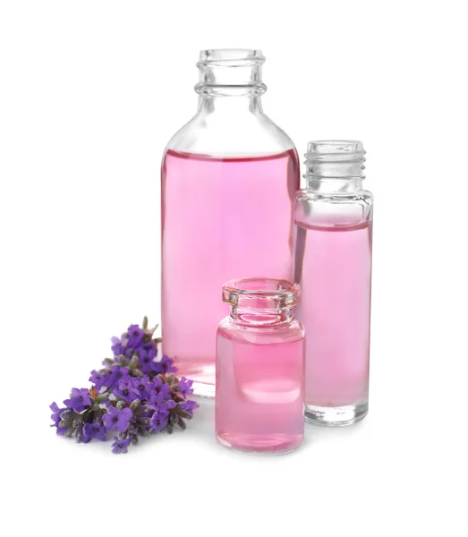 Botellas de aceite esencial y flores de lavanda aisladas en blanco — Foto de Stock