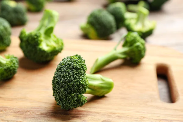 Wooden board with fresh broccoli florets on table, closeup. Space for text — Stock Photo, Image