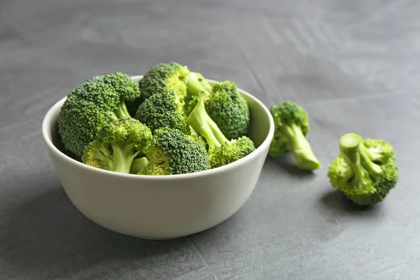 Schaal en verse broccoli op een grijze tafel. Ruimte voor tekst — Stockfoto