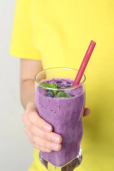 Mulher segurando vidro de delicioso smoothie de mirtilo, close-up — Fotografia de Stock