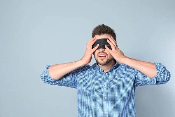 Man med svart ögonbindel på grå bakgrund — Stockfoto