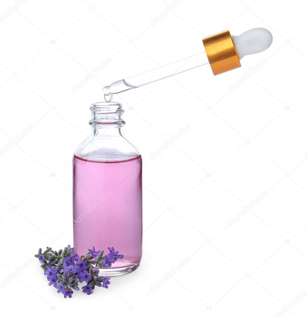 Dripping essential oil from pipette into bottle and lavender flowers isolated on white