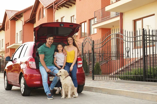 Famille heureuse avec chien près de la voiture dans la rue — Photo