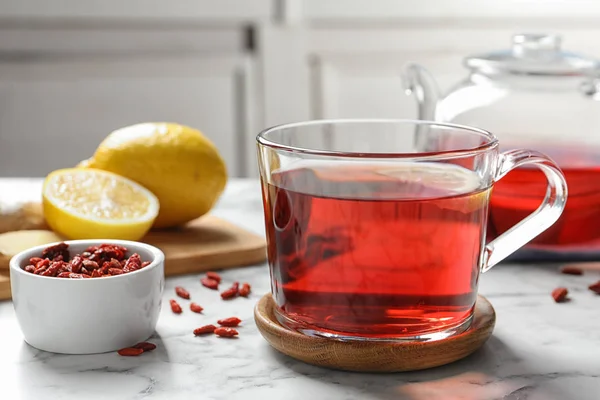 Gesunder Goji-Tee mit Zitrone in Glasschale auf Marmortisch — Stockfoto