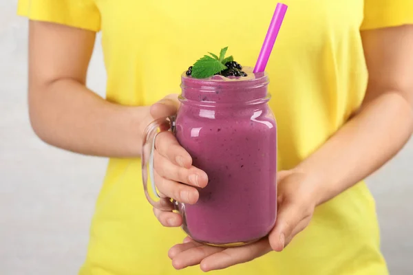 Jonge vrouw het houden van Mason jar van smakelijke BlackBerry smoothie, close-up — Stockfoto