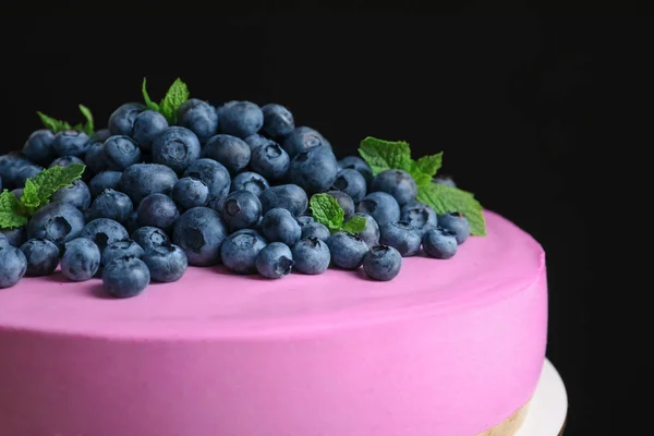 Leckerer Käsekuchen mit frischen Blaubeeren und Minze auf schwarzem Hintergrund, Nahaufnahme — Stockfoto