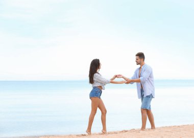 Mutlu genç çift deniz kenarında sahilde birlikte vakit geçirmek