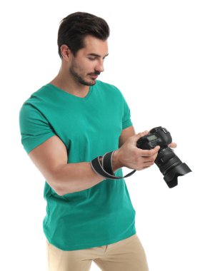 Beyaz arka plan üzerinde profesyonel kamera ile genç fotoğrafçı
