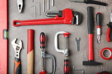 Gri taş masa üzerinde onarım araçları ile düz döşeme kompozisyonu