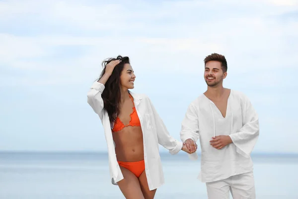 Feliz joven pareja caminando juntos en la playa — Foto de Stock