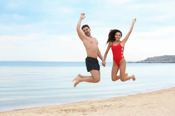 Ευτυχισμένο νεαρό ζευγάρι που διασκεδάζει μαζί στην παραλία κοντά στη θάλασσα — Φωτογραφία Αρχείου
