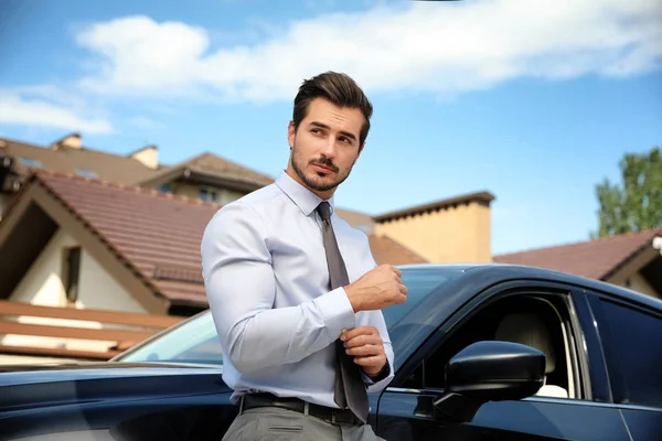 Çekici genç adam yakın lüks araba açık havada