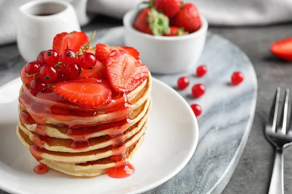 Panquecas deliciosas com bagas frescas e xarope na mesa cinza — Fotografia de Stock